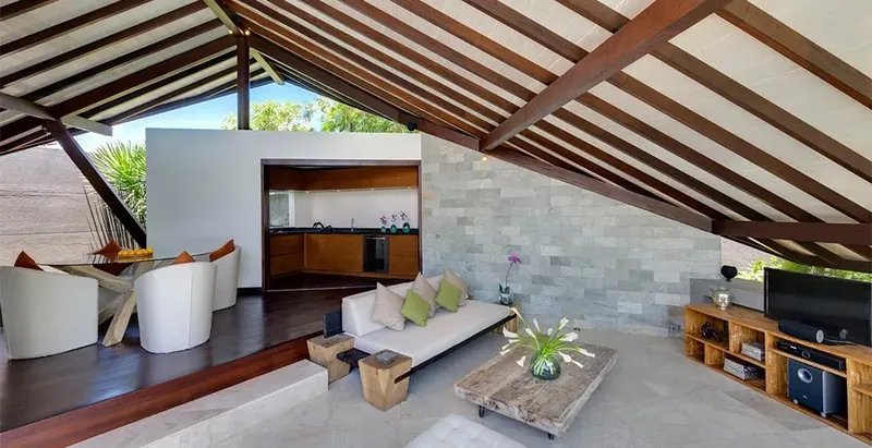 Open-plan living room of a Bali villa under a pitched timber roof